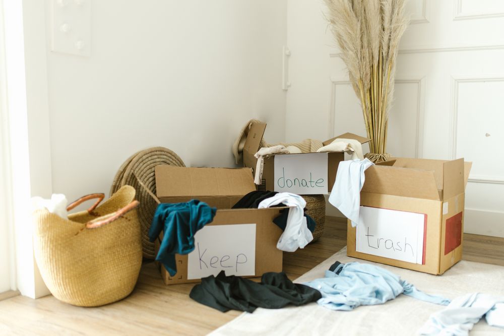 Cardboard boxes labeled keep, donate and trash for decluttering an apartment